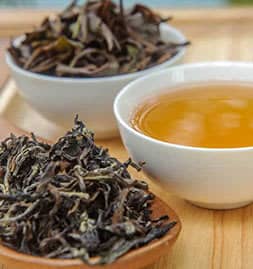 black-tea-online-tea-store black tea in a wooden container and white mug - online tea store concept image