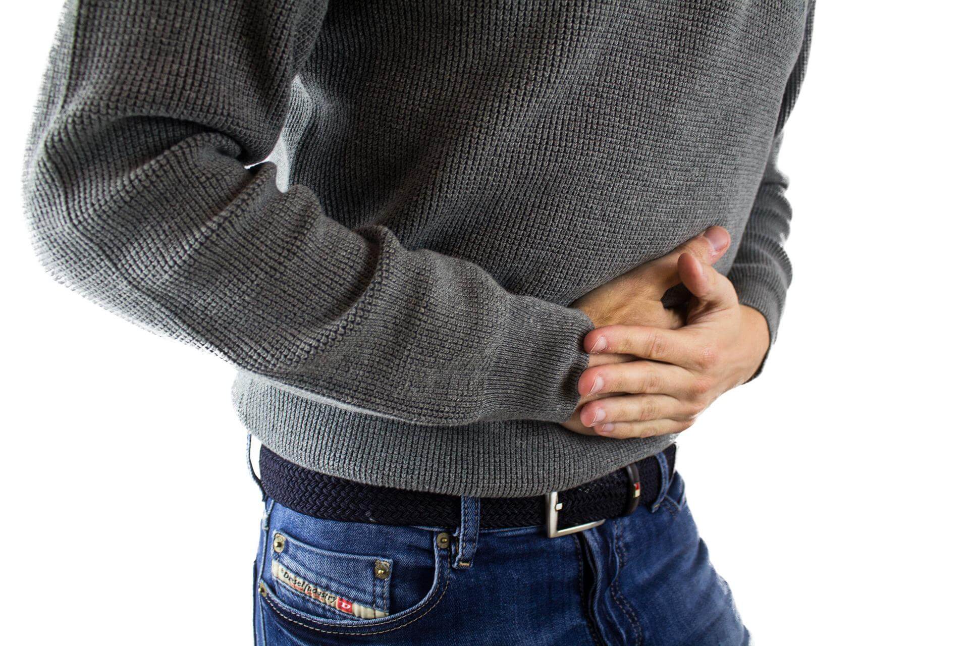 stomach-pain-2821941_1920 (1) Man holding stomach from pain
